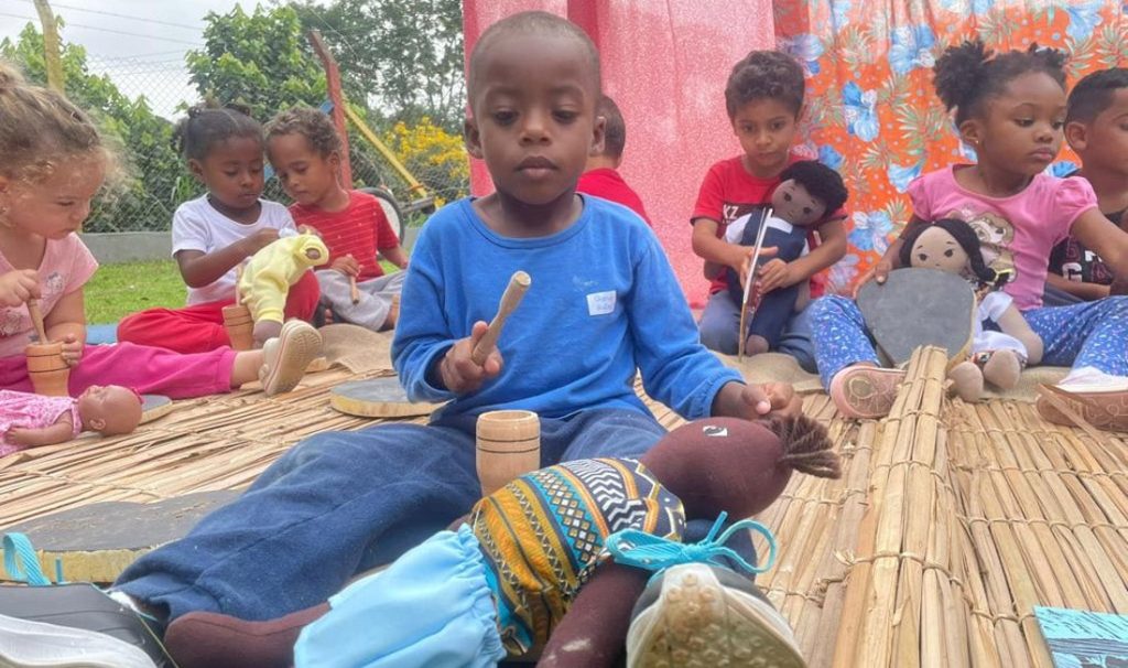 Crianças brincando com bonecos de pano ao ar livre