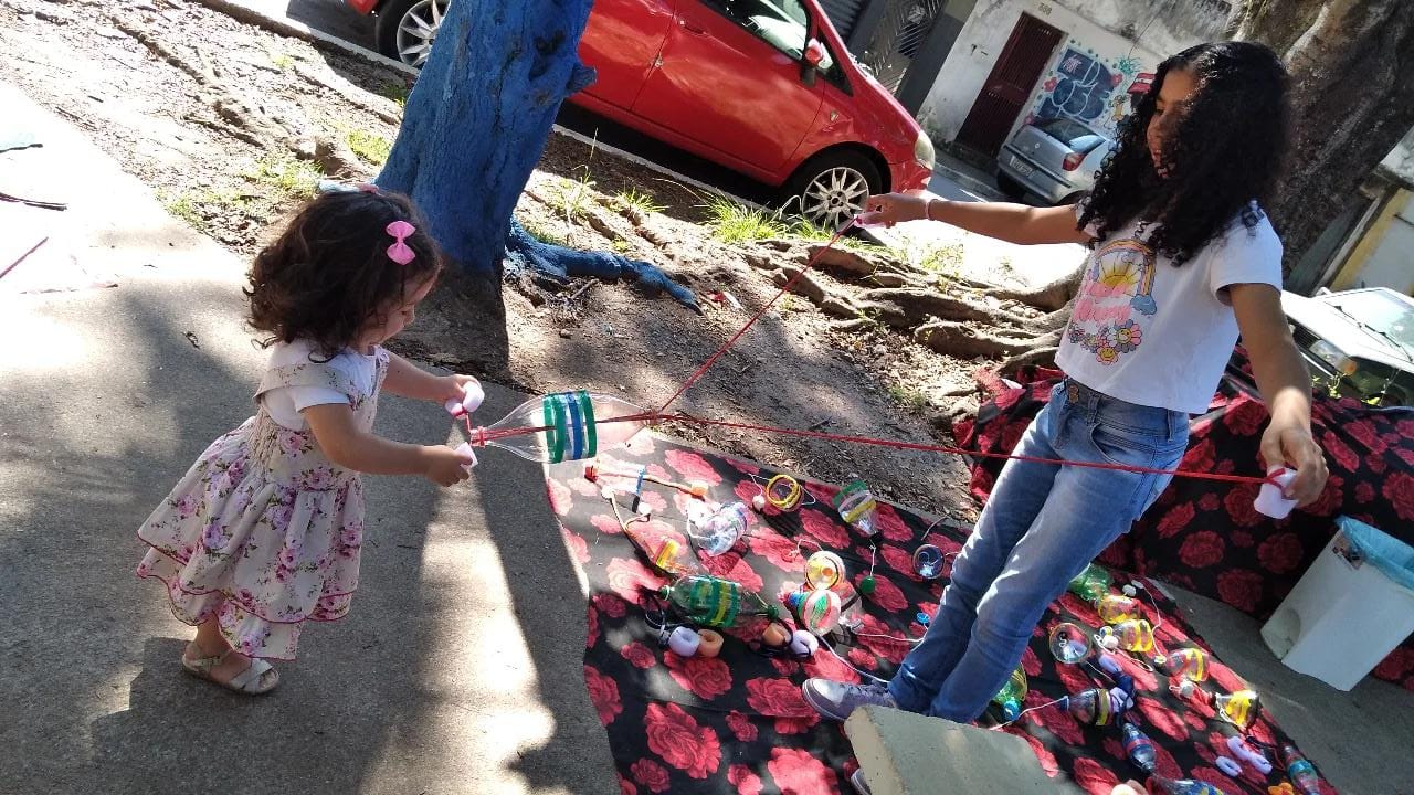 Crianças brincando com brinquedo reciclável